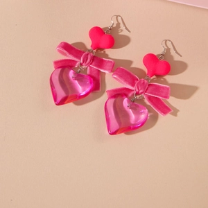 Detail of red velvet bow and pink heart acrylic earrings for Valentine gift