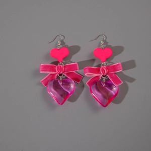 Close-up of pink heart drop earrings with velvet bows and layered resin pendants