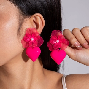 Macro shot of hot pink metal woven flower earrings with white pearls and heart drops