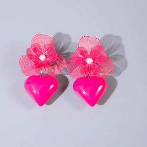 Detailed macro view of magenta heart earrings with white faux pearl and floral cutout