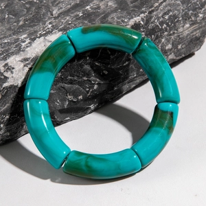 Detail of turquoise leopard print acrylic curved tube beads with faux marble texture