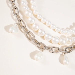 Détail du collier multicouche argenté avec pendentifs perles baroques et ras du cou