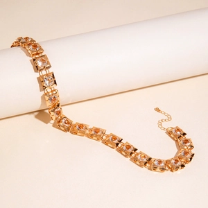 Macro view of gold chain featuring square links and sparkling round zirconia stones