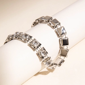 Detail of silver square chain bracelets featuring cubic zirconia and polished metal finish