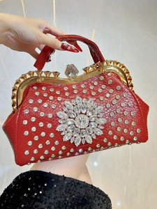 Macro shot of luxury red evening bag with sparkling rhinestones and gold handle