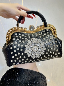 Macro view of crystal flower on luxury black crocodile texture evening handbag
