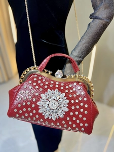 Close-up of red crocodile texture evening bag with crystal flower and gold hardware