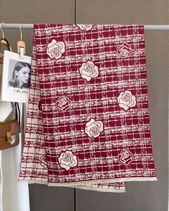Detail of red and white checkered camellia scarf with fine fringe on a hanging display