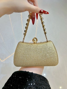 Elegant gold glitter evening clutch with rhinestone chain handle and pearl clasp detail