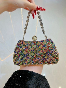 Close-up of luxury rhinestone evening clutch with colorful crystals and pearl clasp detail