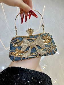 Détail d'une pochette de luxe bleu marine avec notes de musique dorées et nœud diamant