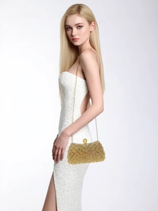 Detailed side view of golden rhinestone clutch with pearl clasp and chain strap