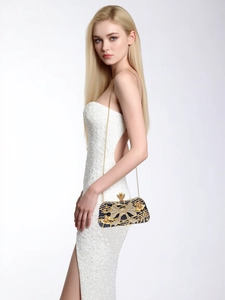 Détail de la pochette de luxe avec nœud en strass et chaîne dorée sur robe de soirée