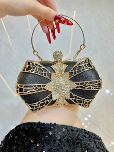 Detail of luxury evening clutch featuring gold hollow metal frame and star crystal emblem