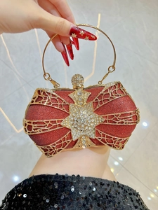 Close-up of red glitter clutch bag with gold wire mesh and rhinestone star detail