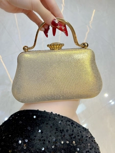 Close-up of luxury gold sequin evening clutch bag with metal handle and vintage clasp