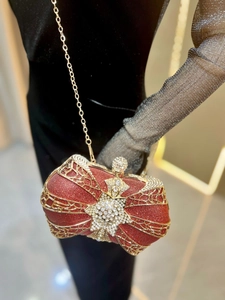 Close-up of luxury red glitter evening clutch with gold filigree and star rhinestone