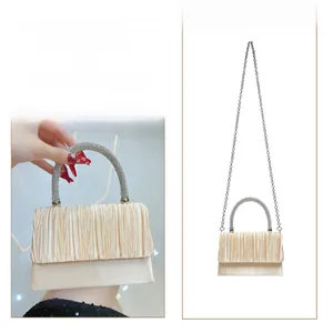 Champagne pleated evening clutch bag with rhinestone handle shown in handbag and crossbody styles