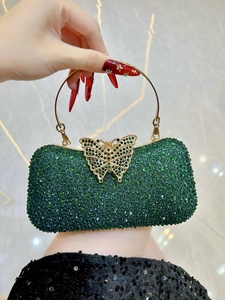 Primer plano de bolso de noche verde esmeralda con cierre de mariposa en pedrería fina