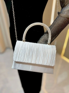 Detail of white pleated evening bag with sparkling rhinestone handle and chain strap