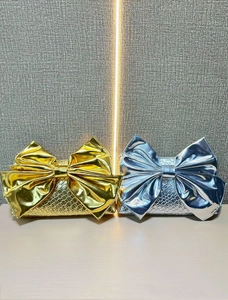 Fashionable women's evening clutch bags with metallic bow designs in gold and silver