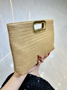 Straw clutch bag with gold metal handle and woven texture for summer evening events
