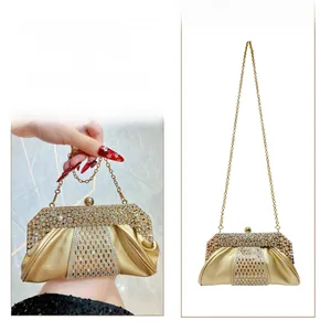 Détail de la pochette de soirée dorée avec strass et chaîne en métal amovible élégante