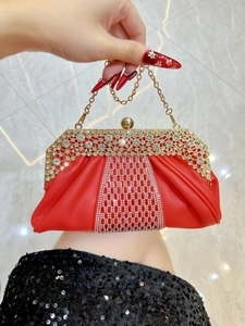 Détail de la pochette de soirée plissée rouge avec strass brillants et fermoir boule dorée