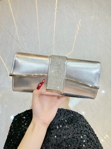 Detail of silver evening clutch with rhinestones and golden metal trim close-up