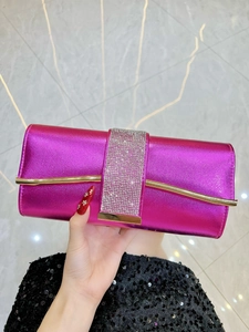 Detail of rose red evening clutch bag with sparkling rhinestone band and metallic finish