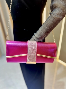 Detail of rose red evening clutch with sparkling rhinestone band and gold chain strap