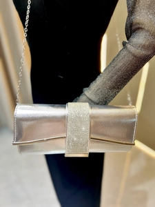Close-up of a silver rectangular evening clutch featuring a sparkling rhinestone center band