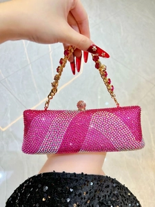 Vue détaillée des strass roses ondulés et de l'anse dorée de cette pochette de luxe