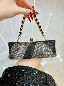 Détail de pochette de soirée de luxe en strass avec motifs diagonaux et chaîne dorée