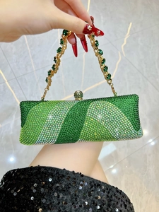 Détail de pochette de soirée luxueuse avec cristaux verts et anse dorée sertie de gemmes