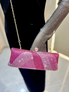 Détail du motif ondulé dégradé en strass rose et blanc sur la pochette de soirée de luxe