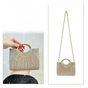 Detail der funkelnden Champagner-Abendtasche mit Metallgriff und goldenem Kettenriemen