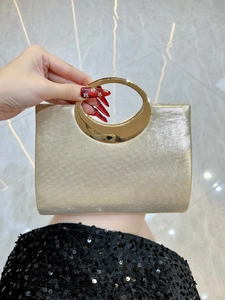 Detail der champagnergoldenen Abendclutch mit glitzerndem Stoff und goldenem Metallgriff