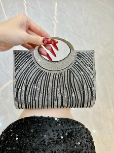 Makroaufnahme der gestreiften Strasssteine an der Clutch mit rundem Metallgriff