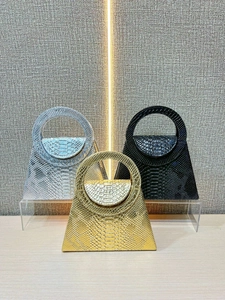 Elegant metallic snakeskin handbags in silver, black, and gold with ring handles