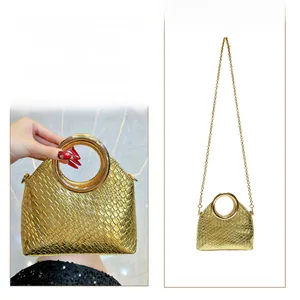 Detailed view of woven gold evening bag with metal handles and chain strap