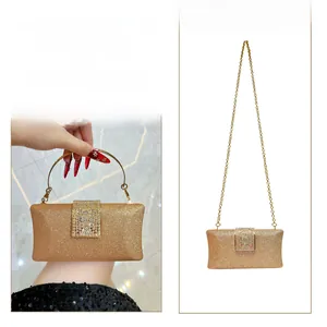 Detail of gold glitter evening bag with crystal buckle, metal ring handle and chain