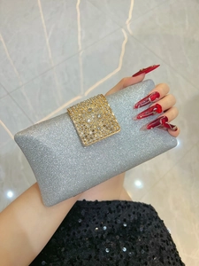 Macro detail of silver sequined evening clutch with gold rhinestone encrusted buckle