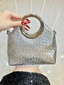 Detail of silver woven texture handbag with metal ring handle and D-ring attachments