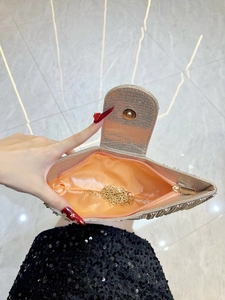 Elegant gold evening clutch with chain tassels and orange satin lining shown from above