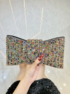 Close-up of a bow-shaped evening clutch bag with vibrant multicolored rhinestones