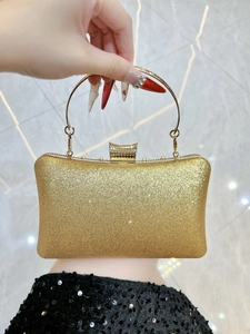 Detail of evening clutch with gold glitter coating and crystal-embellished metal clasp