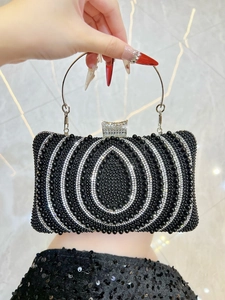 Macro view of woven black and white beads with rhinestone clasp on evening clutch bag