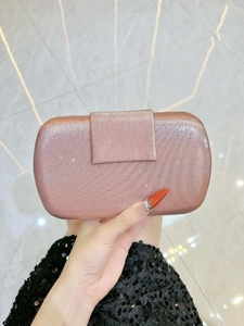 Détail de la pochette de soirée rose avec texture à rayures verticales et paillettes