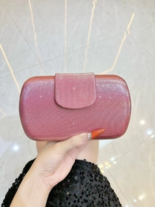 Détail de la pochette à paillettes or rose avec texture rayée et finition scintillante